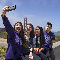 A picture of a group of friends taking a selfie with the Golden Gate Bridge