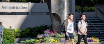 Two student walking in front of Administration building on campus